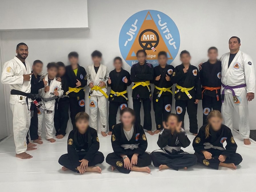 Turma Kids 2 do CTMR Loures: jovens dos 11 aos 14 anos em kimonos com faixas de graduação, de pé e sentados no tatame, com os rostos desfocados